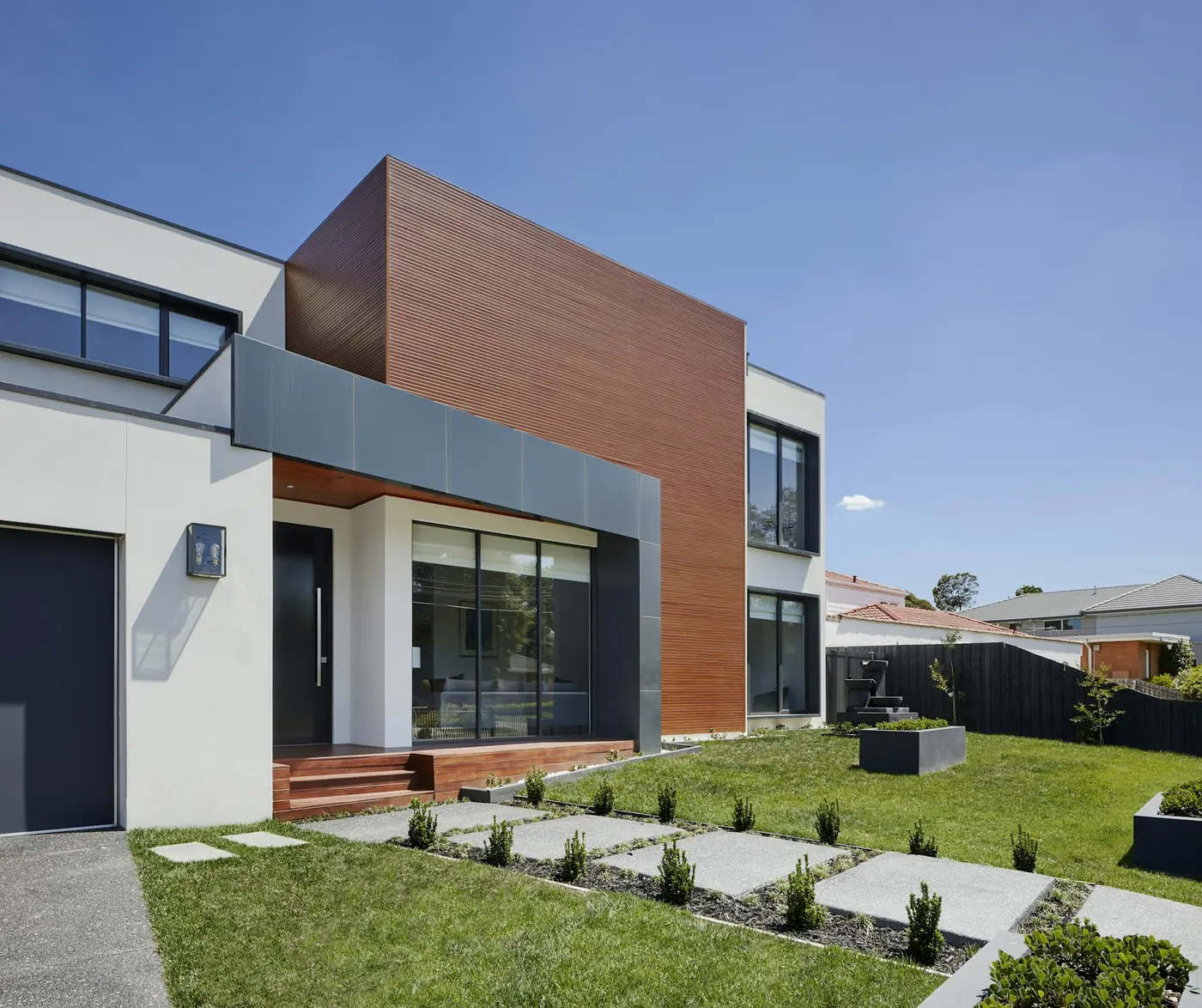 Fachada de vivienda contemporánea con ventanas de PVC y ventanales de termopanel.